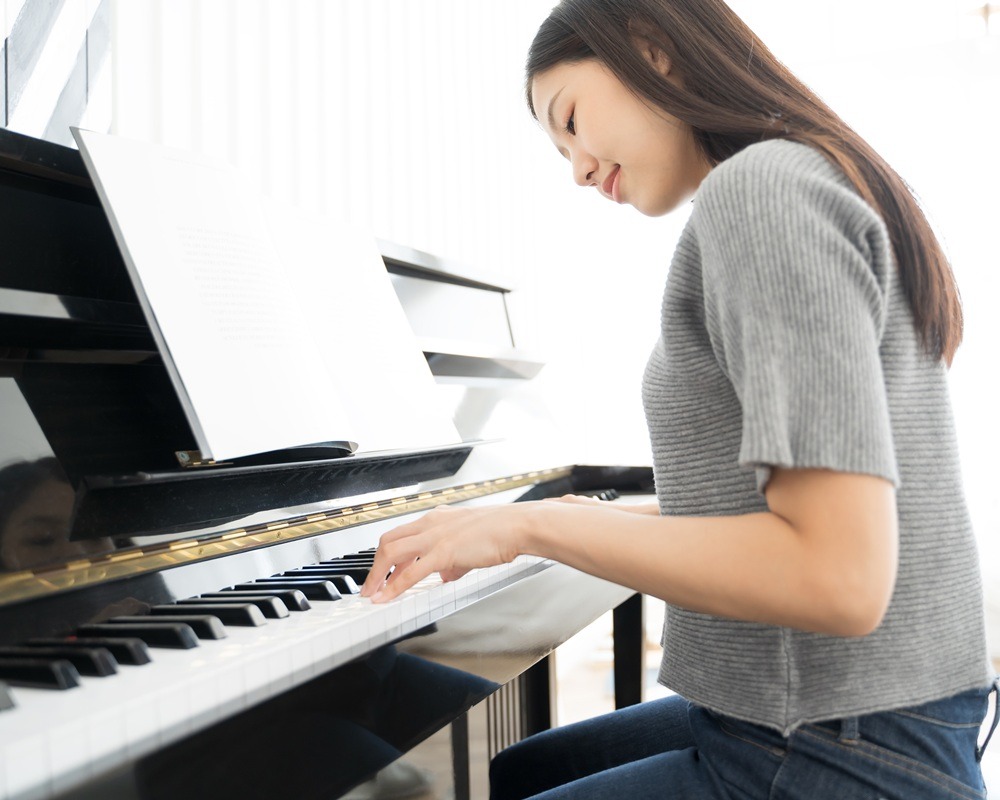 Portrait Asian woman playing playing piano